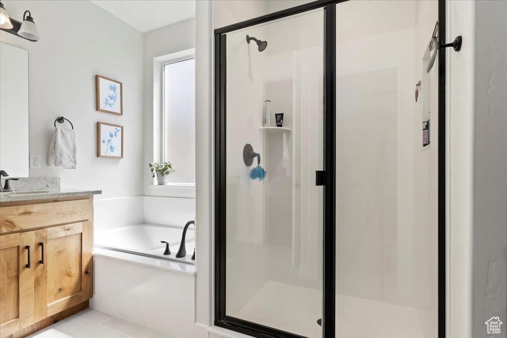 Full bathroom with vanity, a garden tub, and a stall shower