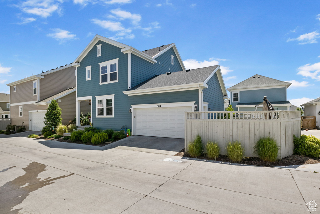 Traditional-style home featuring concrete driveway and a garage