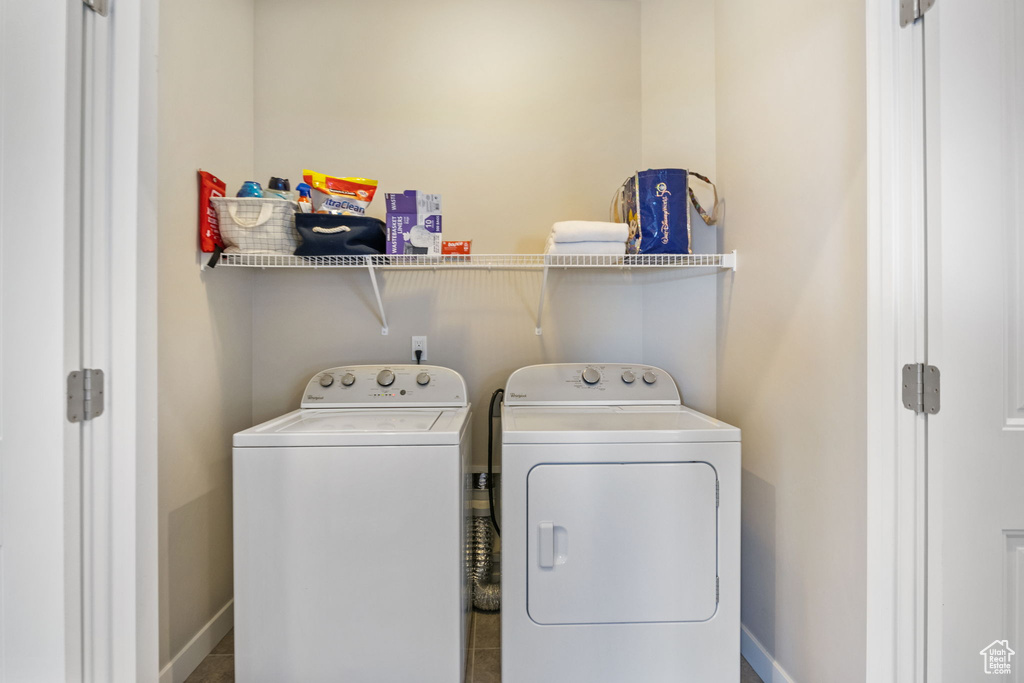 Laundry room featuring washing machine and dryer and baseboards