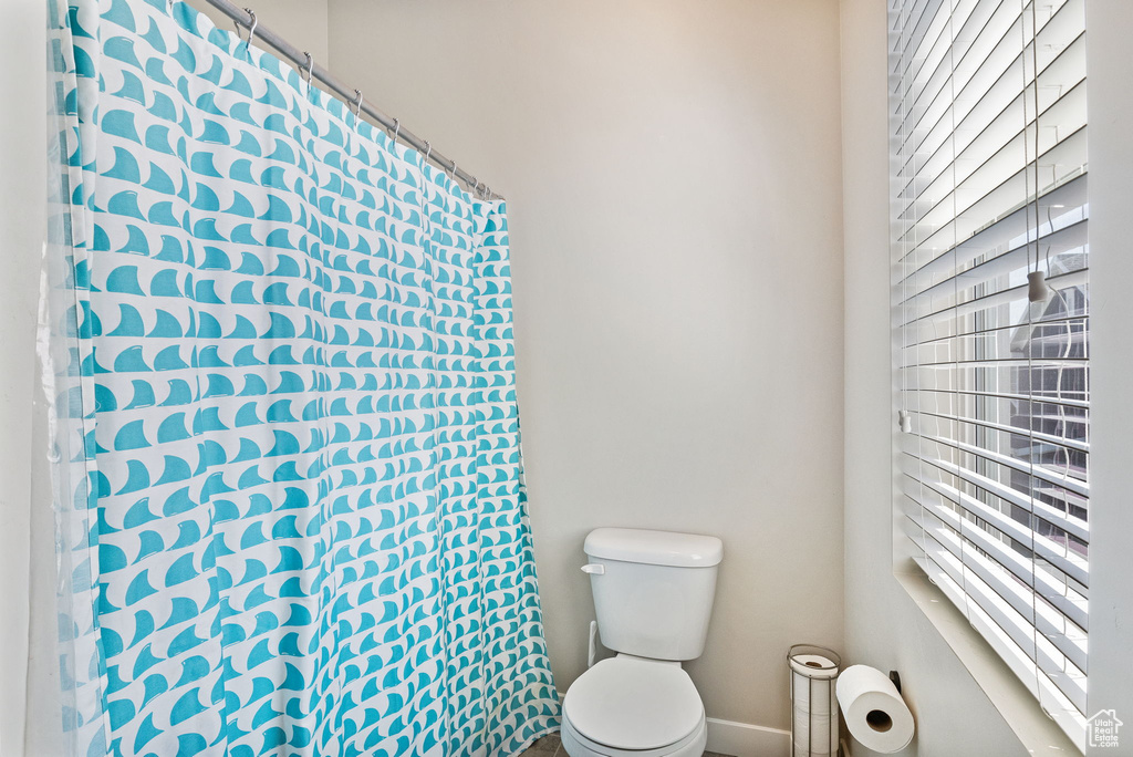 Full bath featuring toilet and baseboards