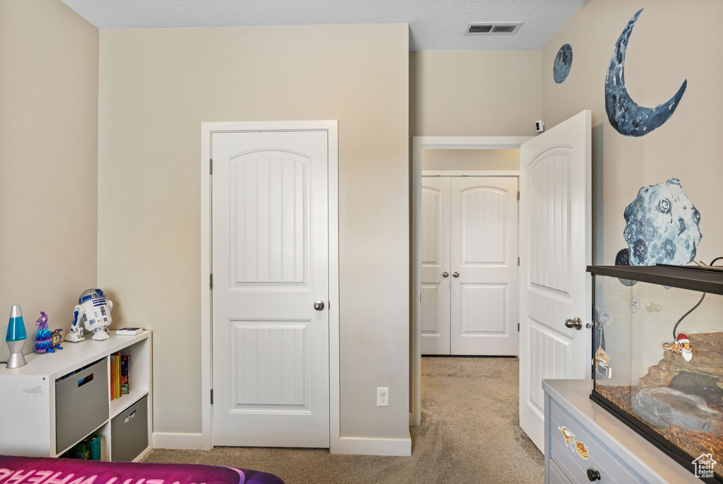 Bedroom with light carpet and baseboards