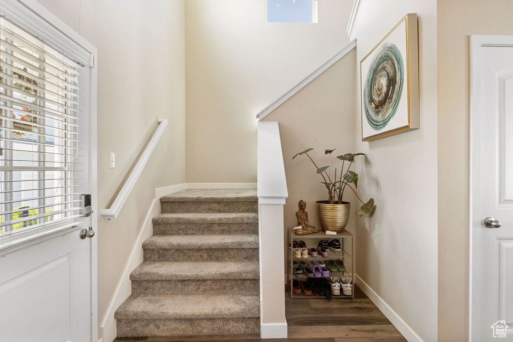 Staircase with wood finished floors and baseboards