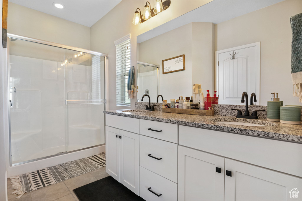 Bathroom featuring double vanity, a stall shower, tile patterned floors, and recessed lighting