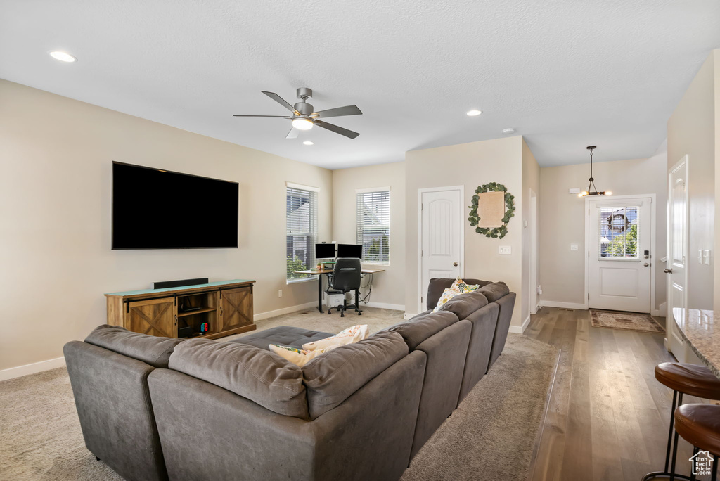 Living area with plenty of natural light, baseboards, recessed lighting, a ceiling fan, and a chandelier