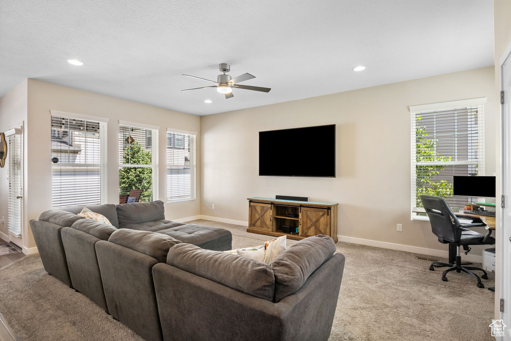 Living area featuring baseboards, ceiling fan, a desk, recessed lighting, and light carpet