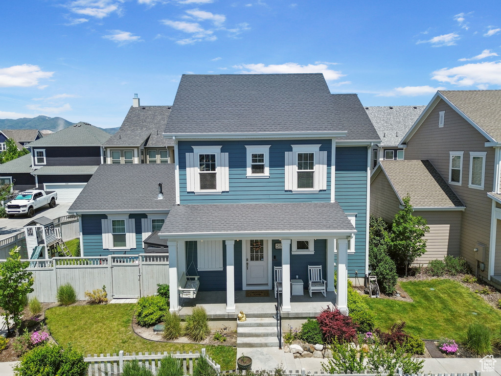 View of front of property with roof with shingles, a residential view, a porch, and a gate