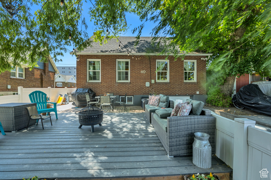 Deck featuring an outdoor living space with a fire pit and grilling area