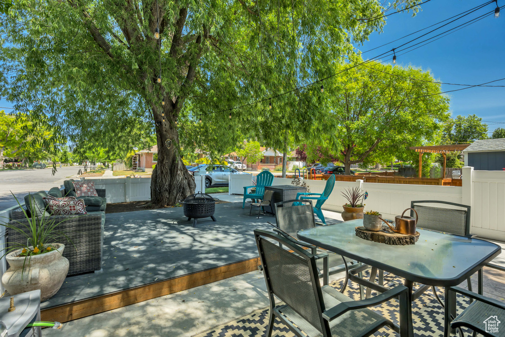 View of patio / terrace with a fire pit and outdoor dining area
