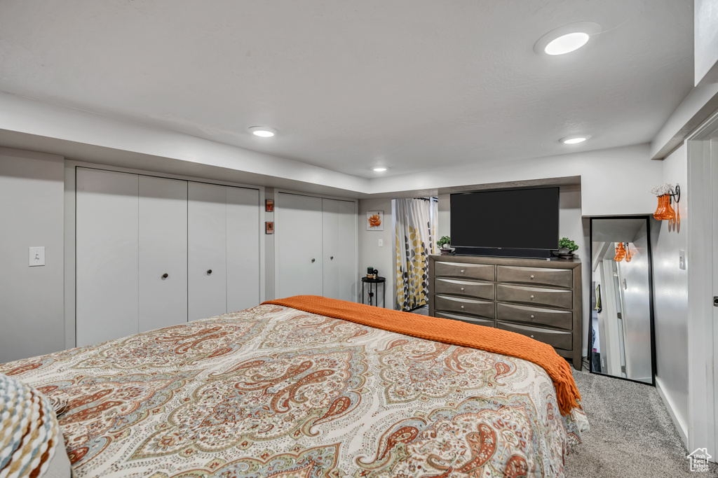 Carpeted bedroom featuring multiple closets and recessed lighting