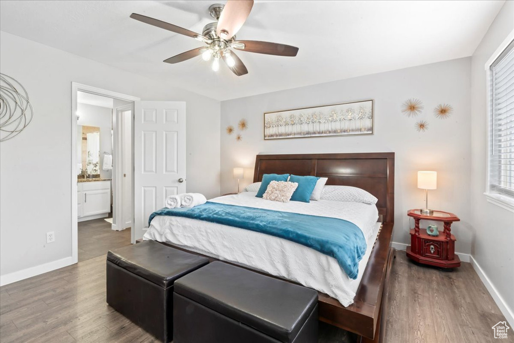 Bedroom featuring wood finished floors, baseboards, multiple windows, and a ceiling fan