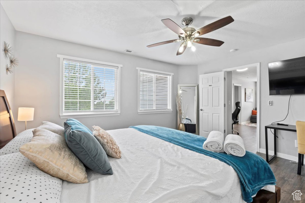 Bedroom featuring wood finished floors, a ceiling fan, and baseboards