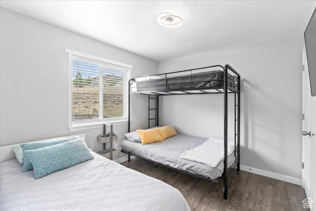 Bedroom with wood finished floors and baseboards