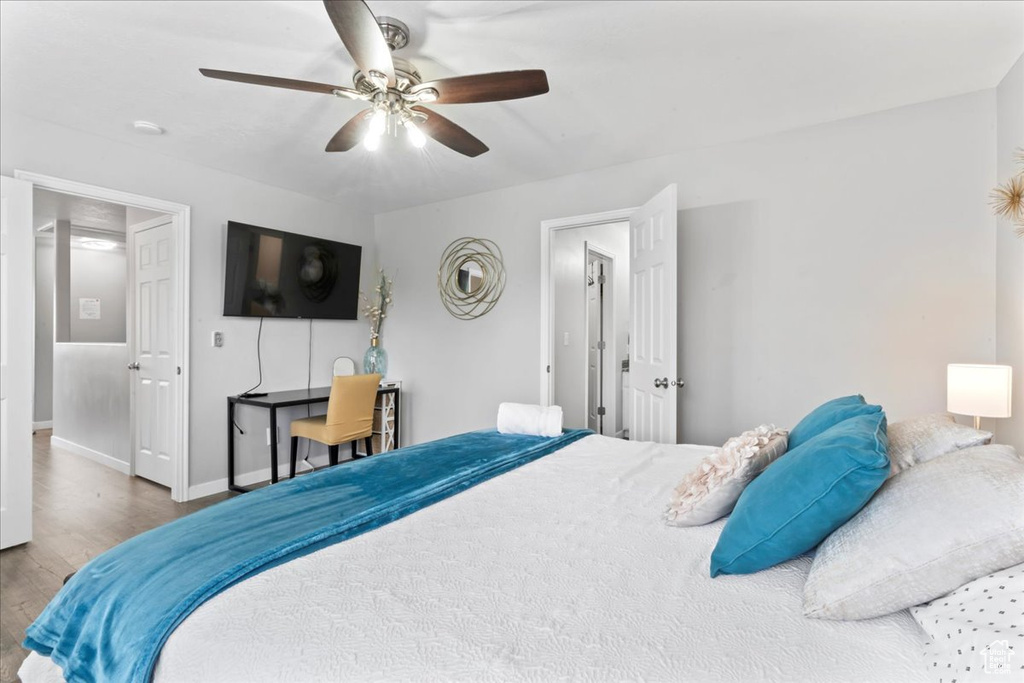 Bedroom featuring wood finished floors, baseboards, and a ceiling fan