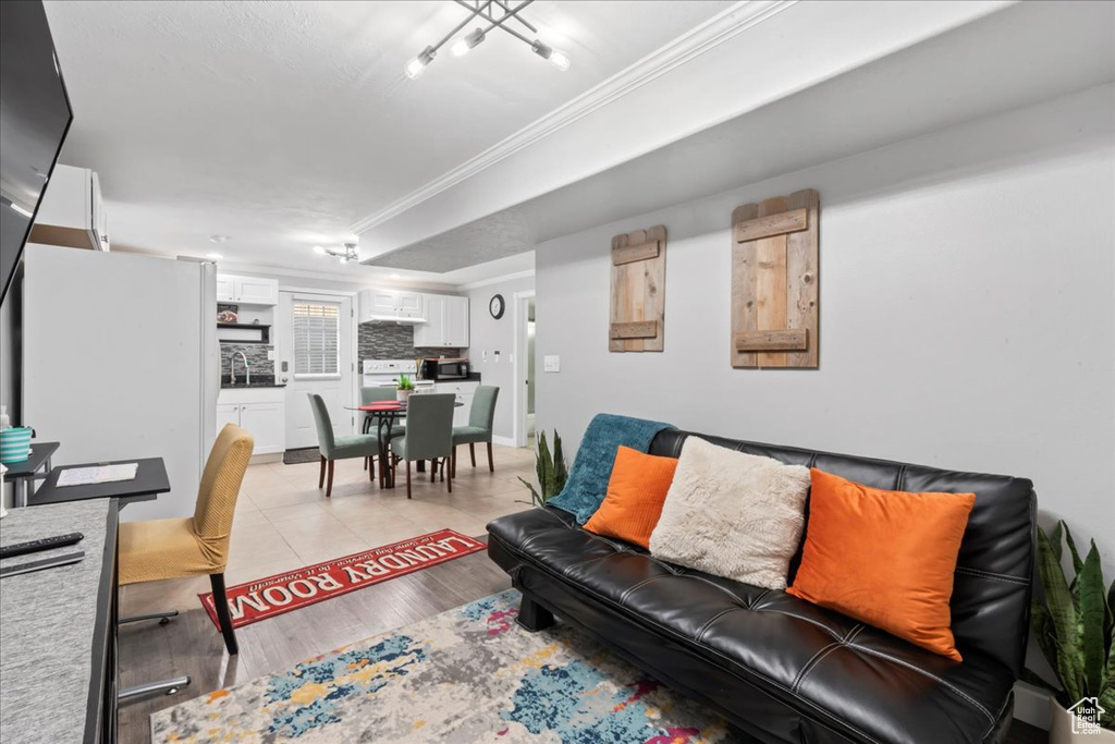 Living room with crown molding and light wood finished floors