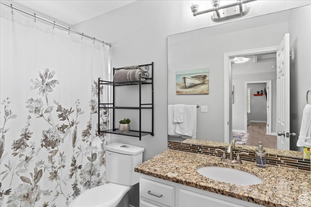 Bathroom featuring vanity, toilet, and a shower with shower curtain
