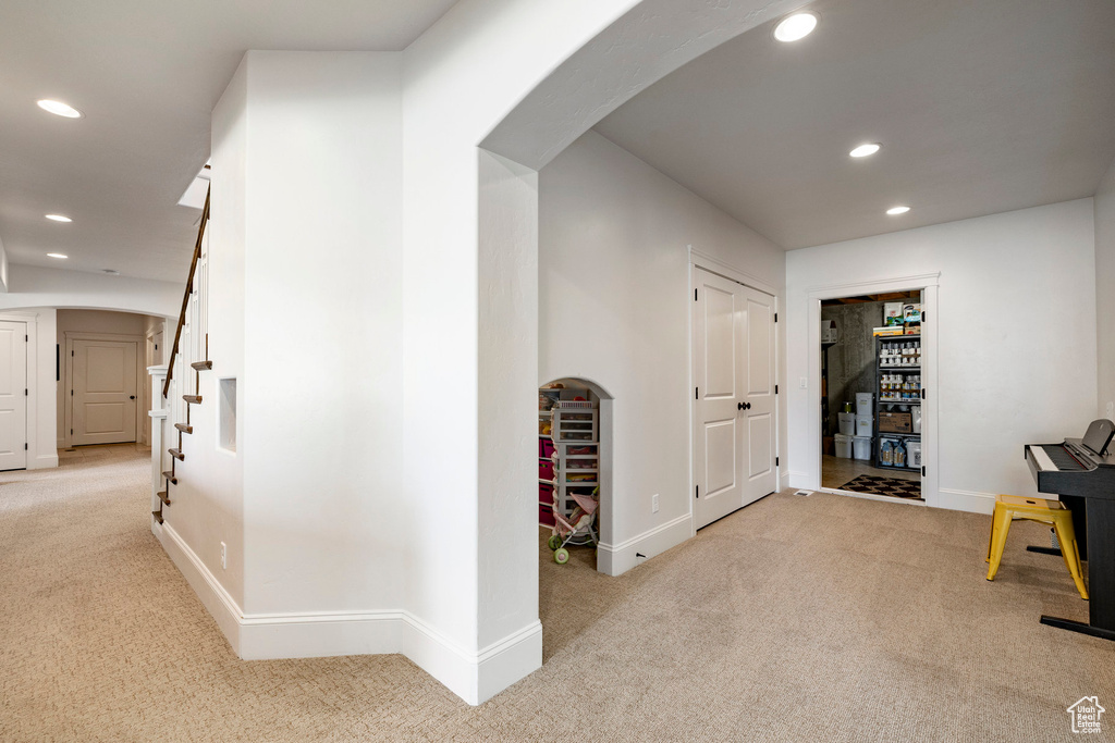Hall featuring carpet flooring, recessed lighting, arched walkways, baseboards, and stairs