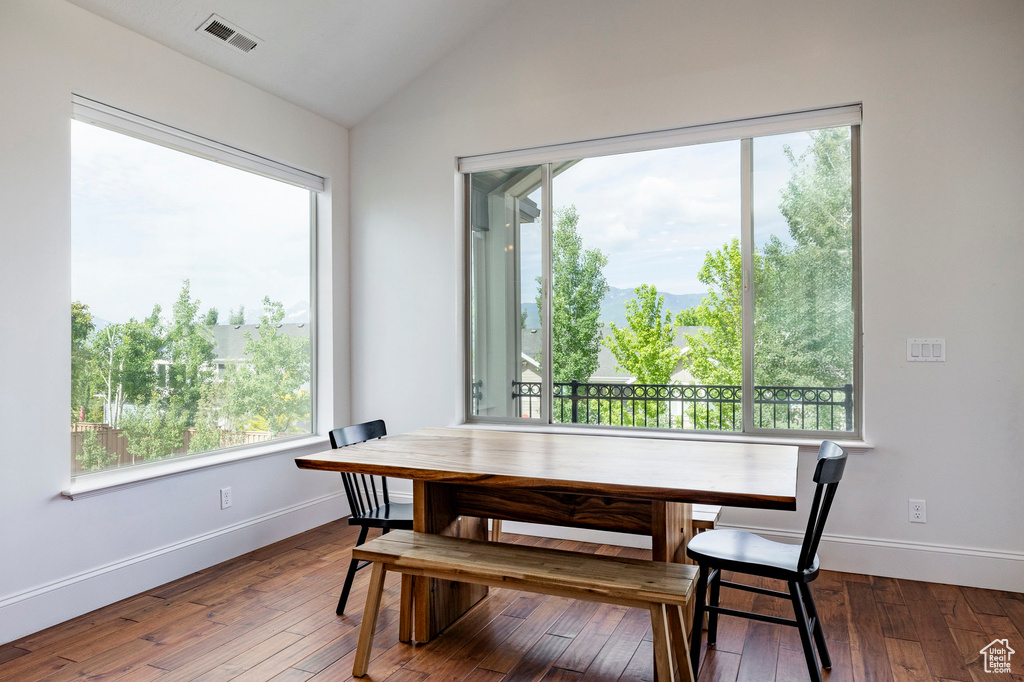 Dining area with vaulted ceiling, baseboards, wood-type flooring, and a mountain view