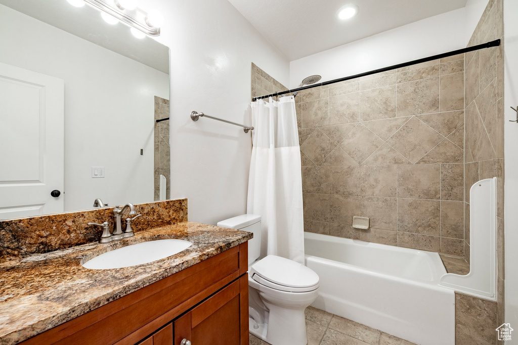 Bathroom featuring vanity, toilet, shower / bathtub combination with curtain, and tile patterned floors