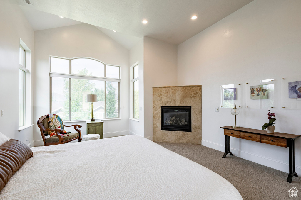 Carpeted bedroom featuring high vaulted ceiling, a fireplace, recessed lighting, and baseboards