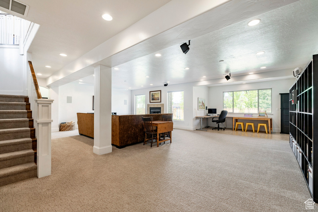 Living room with light carpet, recessed lighting, baseboards, an office area, and stairs