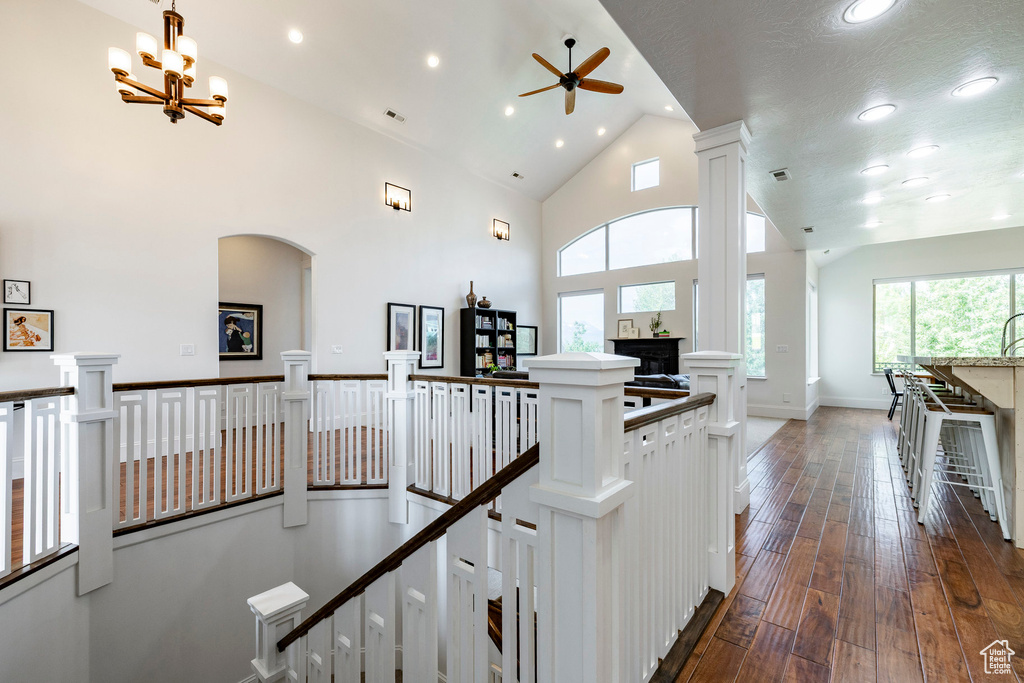 Hallway with an upstairs landing, recessed lighting, plenty of natural light, dark wood finished floors, and high vaulted ceiling