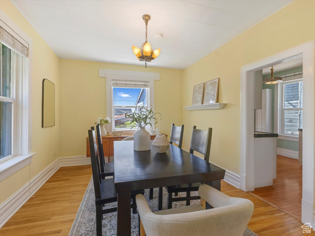 Dining space featuring light wood finished floors, a chandelier, and baseboards