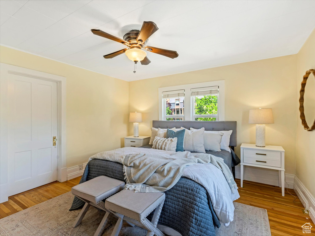 Bedroom with wood finished floors, baseboards, and a ceiling fan