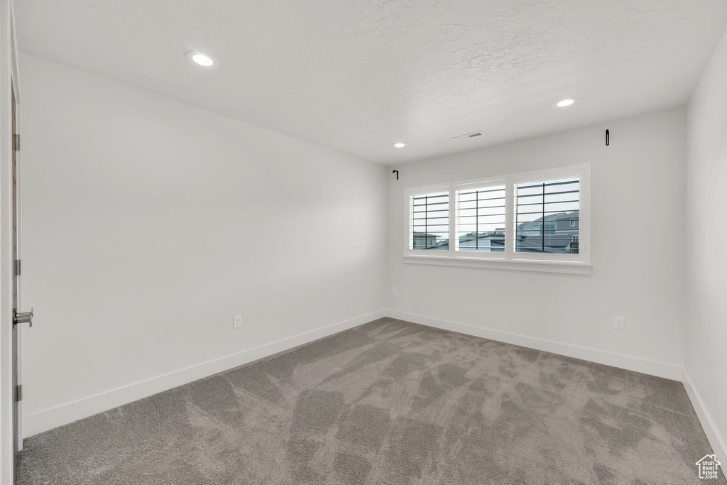Carpeted spare room featuring recessed lighting and baseboards