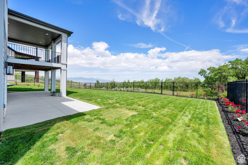 View of yard with a balcony, a patio area, and a mountain view