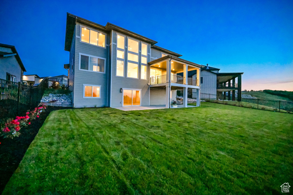 Back of property with a balcony and a patio area