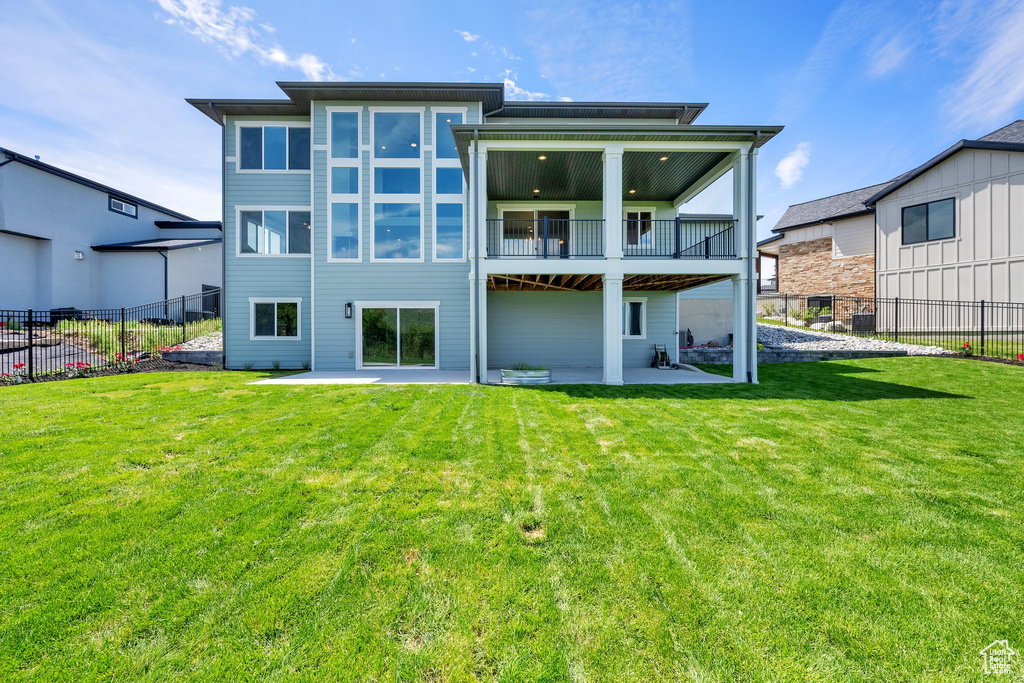 Back of house with a balcony and a patio area