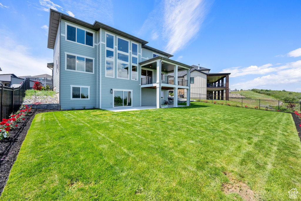 Rear view of house with a patio area and a balcony