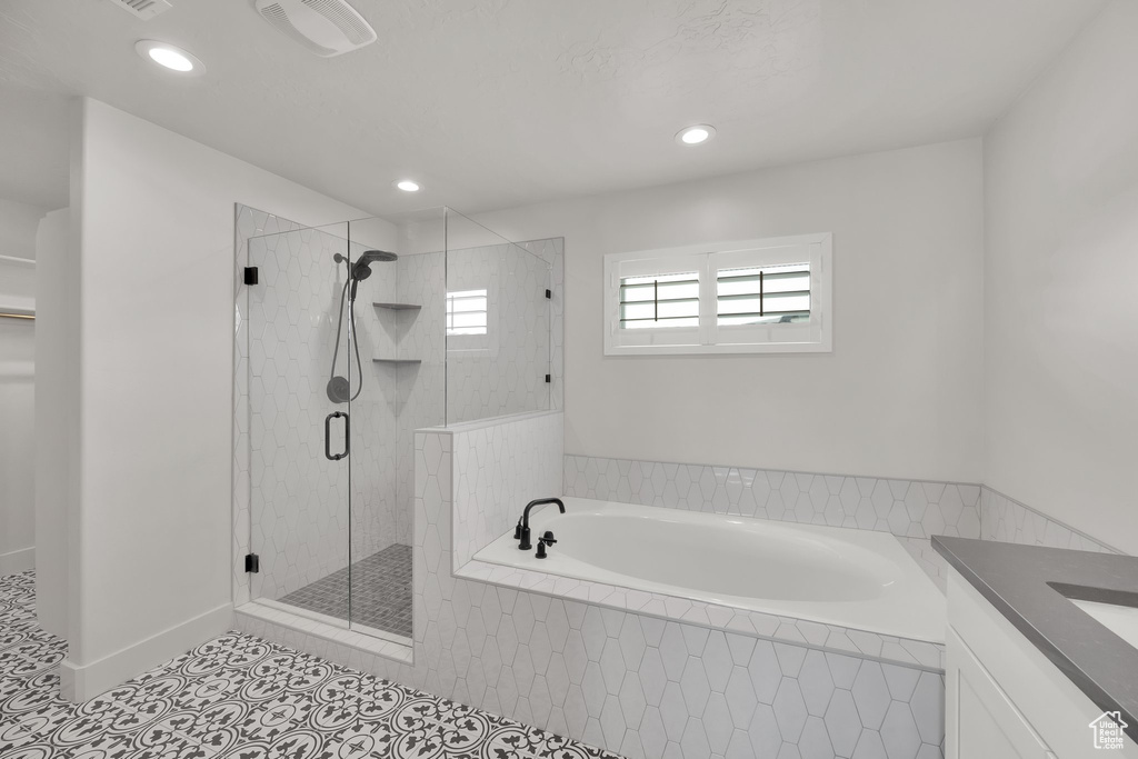 Full bath featuring a bath, a shower stall, tile patterned floors, recessed lighting, and vanity