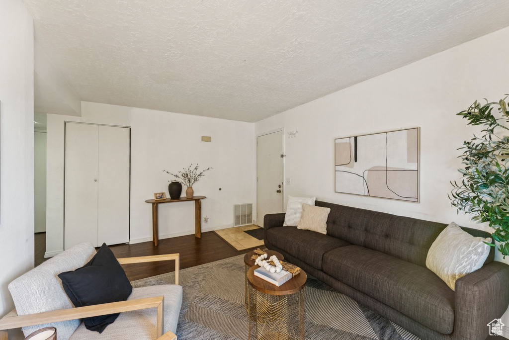 Living area featuring wood finished floors and a textured ceiling