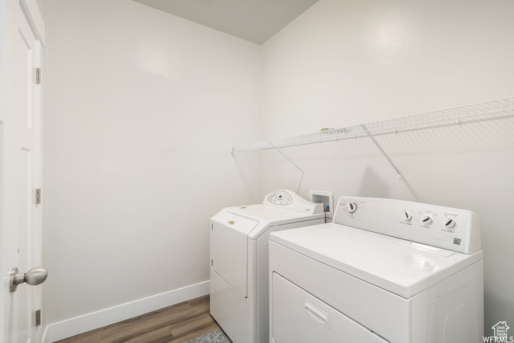 Washroom featuring separate washer and dryer, baseboards, and light wood-style floors