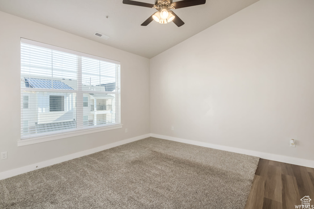 Spare room featuring baseboards, a ceiling fan, lofted ceiling, and carpet