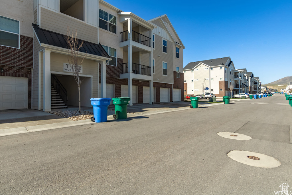 View of asphalt street featuring a residential view and sidewalks