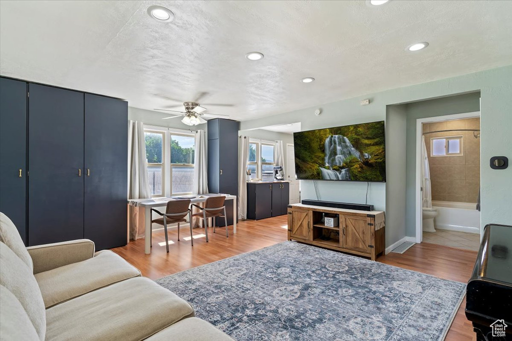 Living room with ceiling fan, recessed lighting, and light wood-style flooring