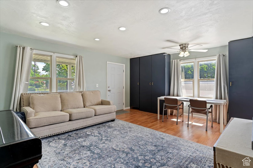 Living area with recessed lighting, wood finished floors, and ceiling fan
