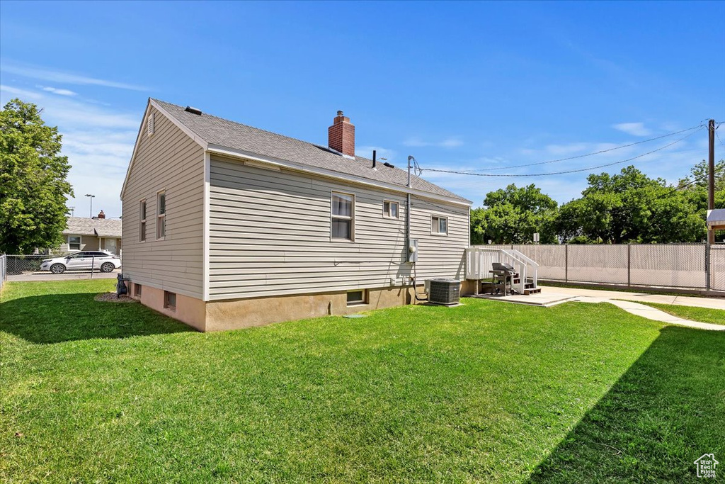 Back of property with a chimney, cooling unit, and a patio area