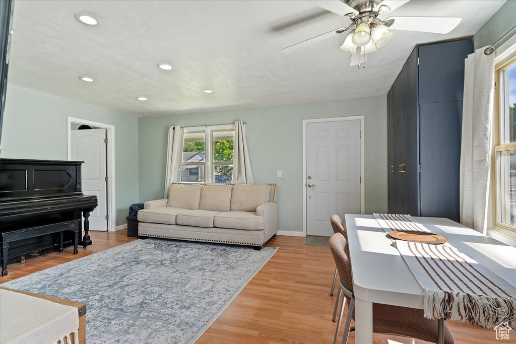 Living room with recessed lighting, a ceiling fan, baseboards, and light wood-style flooring