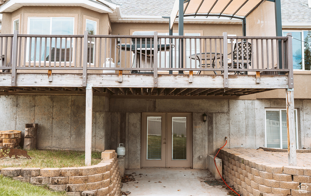 Back of property featuring french doors, stucco siding, and a shingled roof