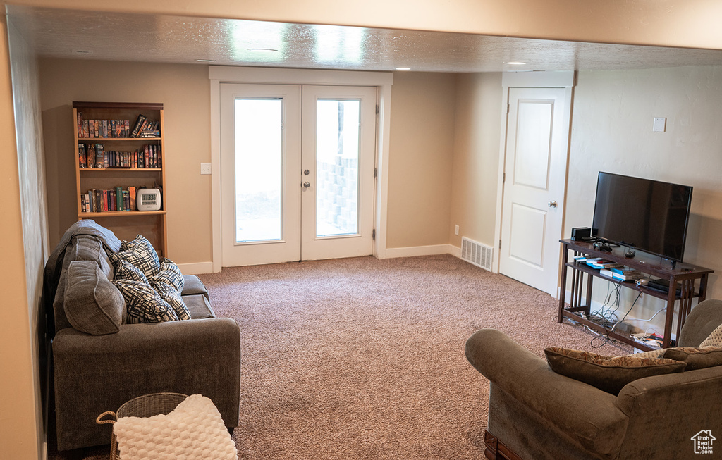 Living area with french doors, carpet, and baseboards