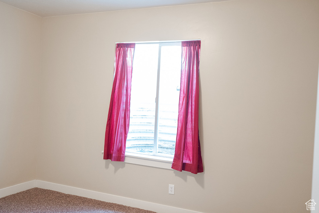 Carpeted empty room featuring baseboards