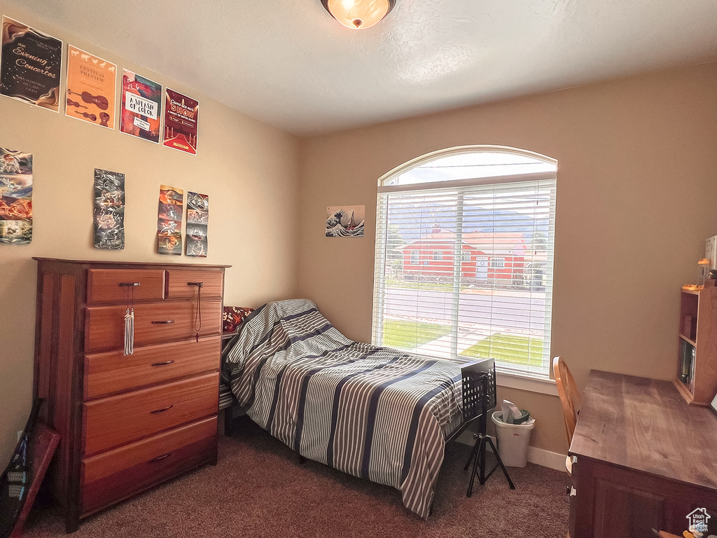 Bedroom featuring dark carpet