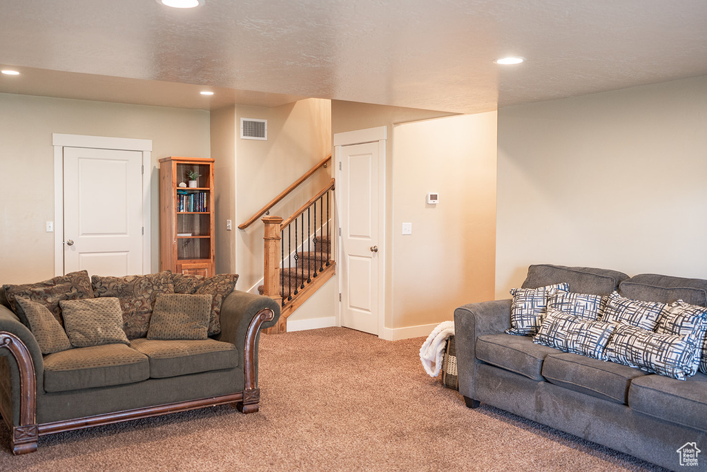 Living area featuring carpet floors, stairs, recessed lighting, and baseboards