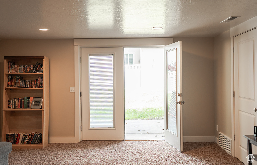 Doorway featuring carpet floors, a textured ceiling, baseboards, and recessed lighting
