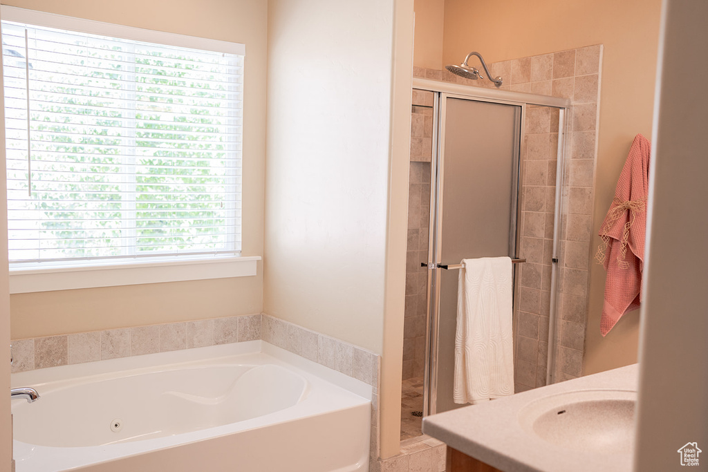 Bathroom featuring a stall shower and a whirlpool tub