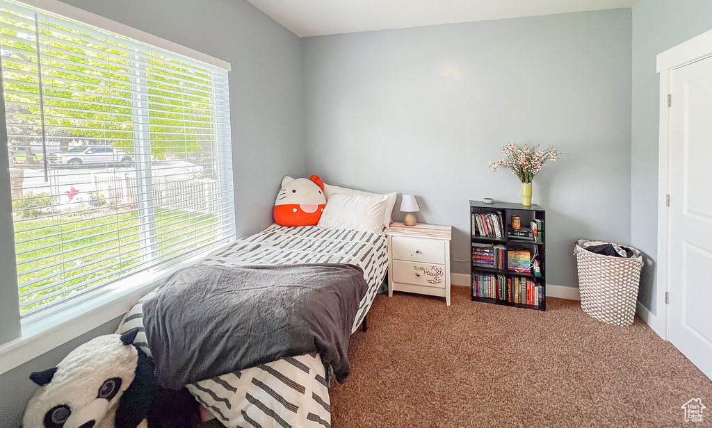 Carpeted bedroom featuring multiple windows and baseboards