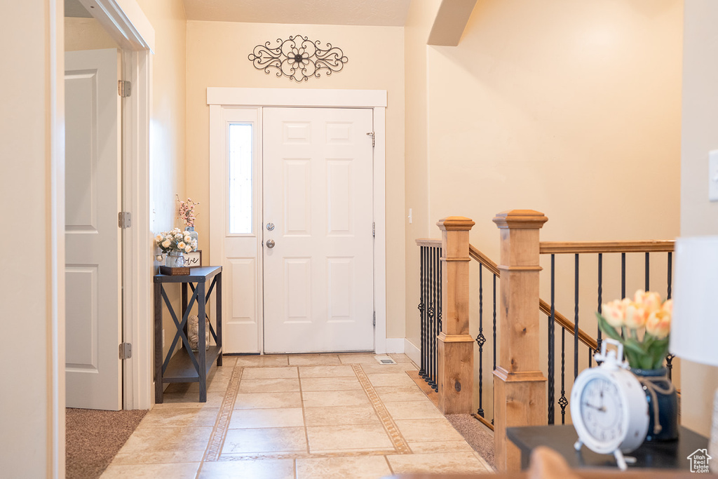 Entryway with inlaid floor details and baseboards